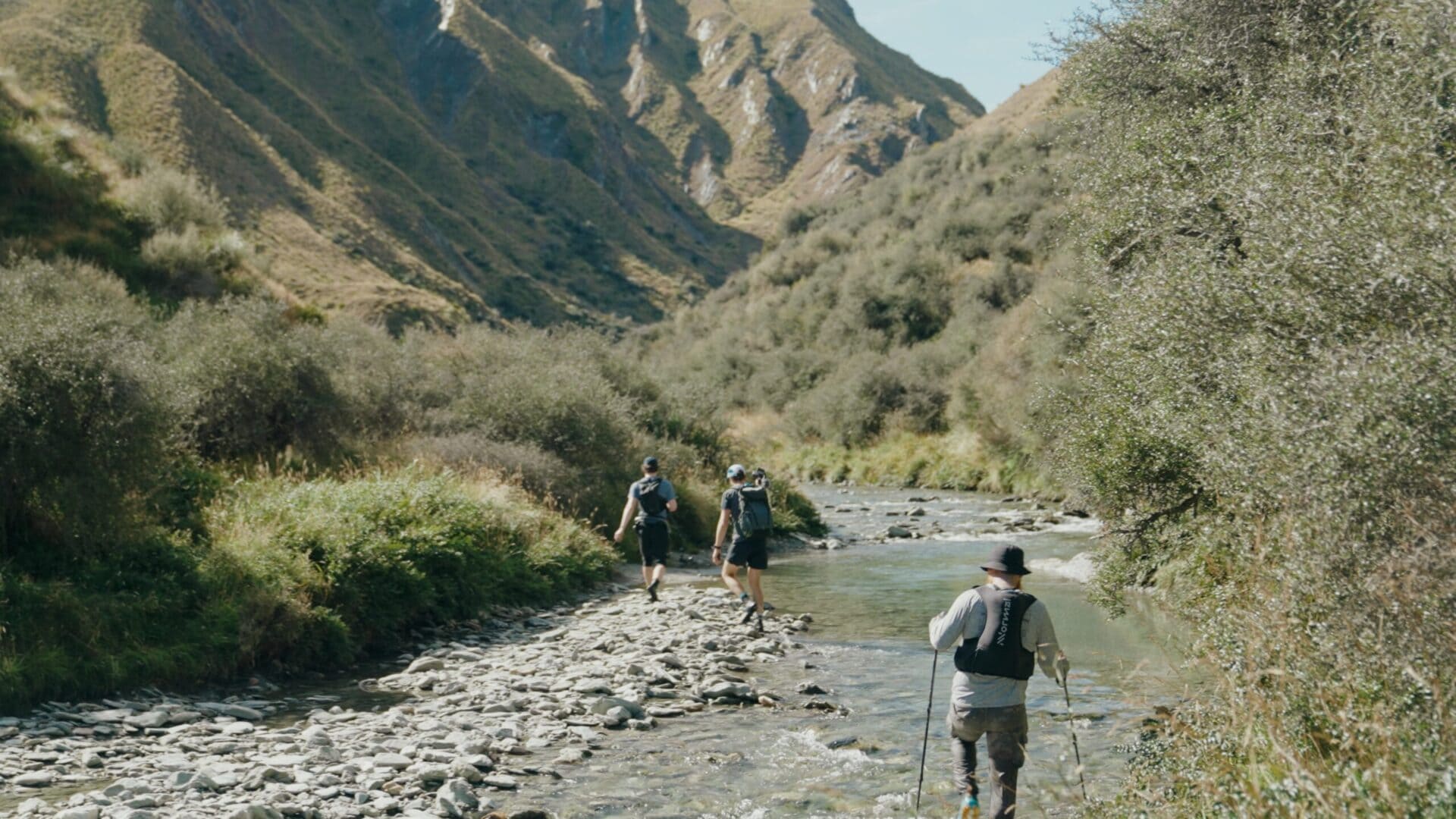 trampers walking down mountain river