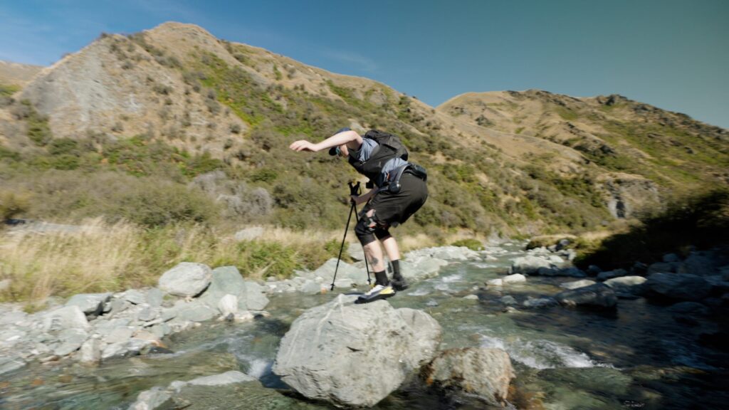 Ben crossing a river on the boulders