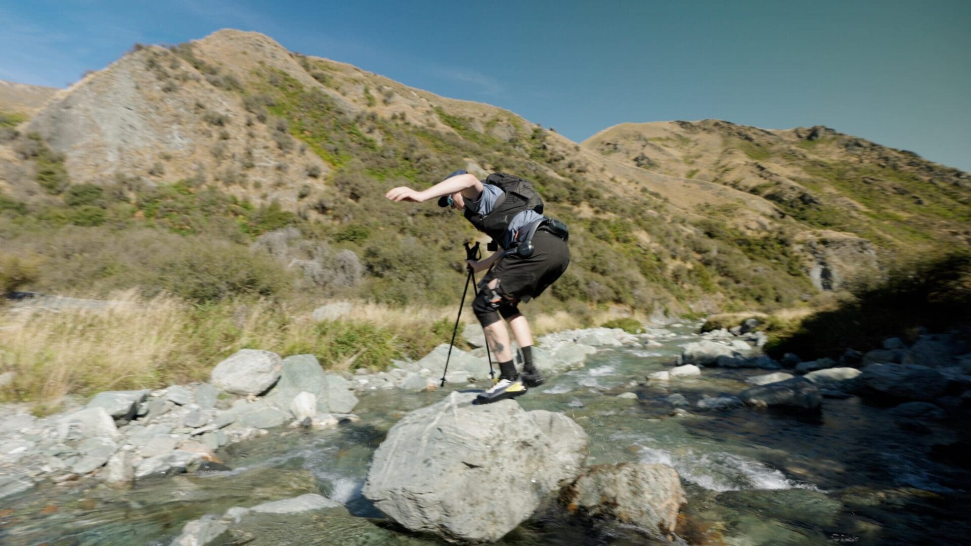 Ben crossing a river on the boulders